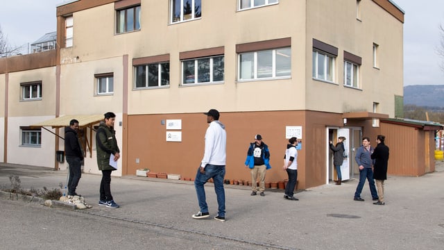 Symbolbild: Männer vor einem Haus. Symbolbild: Männer vor einem Haus.