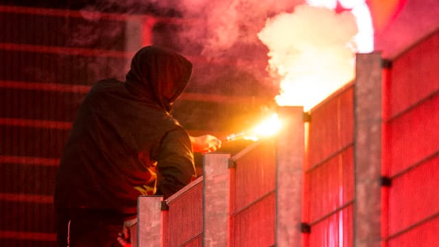 Fussballhooligan mit einer Pyrofackel in der Hand. Fussballhooligan mit einer Pyrofackel in der Hand.