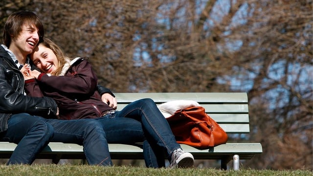 Junges Paar auf einer Parkbank Junges Paar auf einer Parkbank