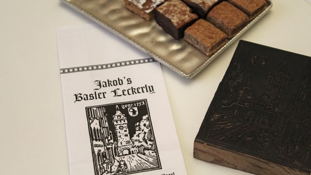 Läckerli, eine Papiertüte und ein Holzschnitt Läckerli, eine Papiertüte und ein Holzschnitt