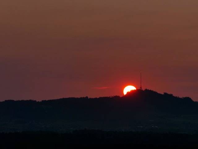 Neben dem Sendemast am Bantiger geht die Sonne auf, der Himmel ist dunkelrot verfärbt. Neben dem Sendemast am Bantiger geht die Sonne auf, der Himmel ist dunkelrot verfärbt.