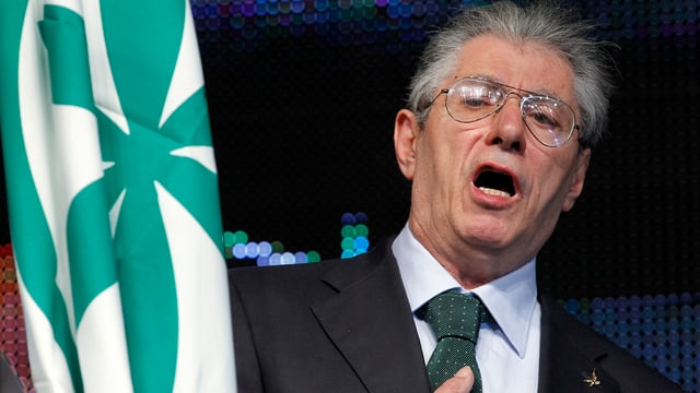 Bossi mit Brille neben einer Flagge. Bossi mit Brille neben einer Flagge.