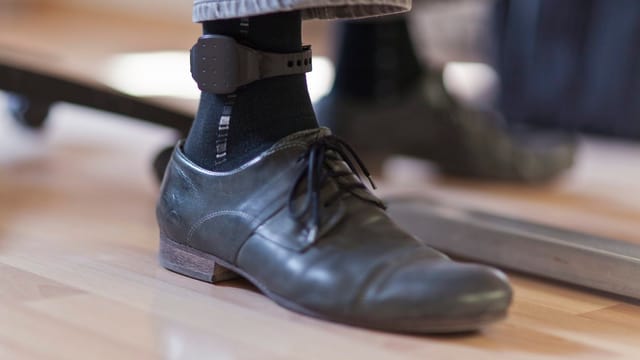 Mann mit elektronischer Fussfelle am Knöchel Mann mit elektronischer Fussfelle am Knöchel