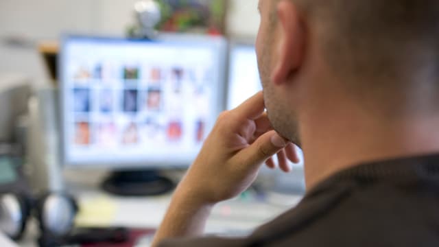 Beamter schaut auf Bildschirm Beamter schaut auf Bildschirm