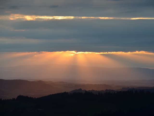 Abendstimmung, durch Wolkenlücken sind Sonnenstrahlen sichtbar.