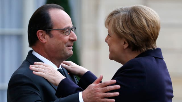 François Hollande und Angela Merkel geben sich eine Umarmung François Hollande und Angela Merkel geben sich eine Umarmung