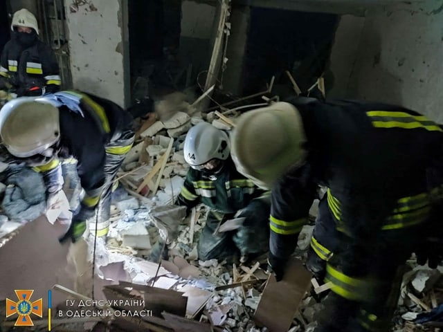 Rettungsleute in Trümmern.