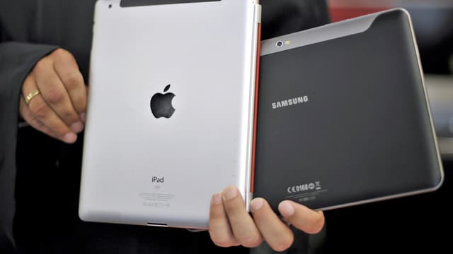 Ein Mann zeigt einen Apple- und Samsung Tablet-Computer. (keystone) Ein Mann zeigt einen Apple- und Samsung Tablet-Computer. (keystone)