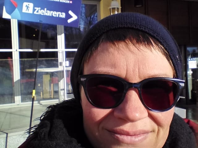 Selfie von Frau mit Sonnenbrille, im Hintergrund Schild mit Aufschrift «Zielarena»