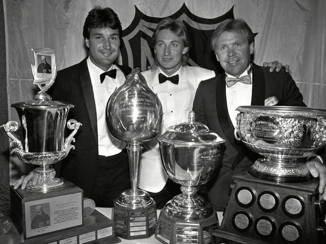 Paul Coffey, Wayne Gretzky und Coach Glenn Sather (v.l.n.r.) zeigen ihre Trophäen. Paul Coffey, Wayne Gretzky und Coach Glenn Sather (v.l.n.r.) zeigen ihre Trophäen.