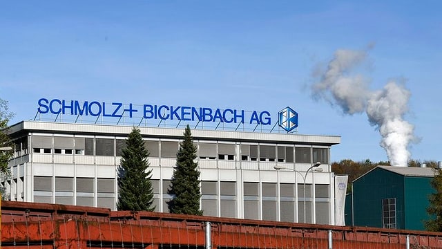 Eine Fabrik mit einem rauchenden Kamin. Eine Fabrik mit einem rauchenden Kamin.