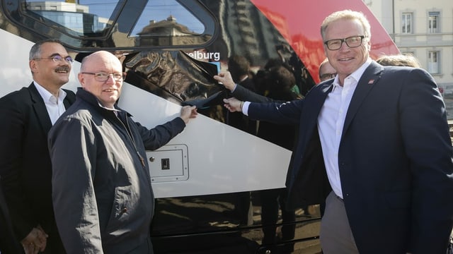 Zwei Männer weihen neuen Zug ein. Zwei Männer weihen neuen Zug ein.