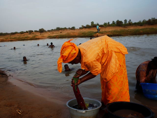 Frau wächst ihre Kleider im Senegal-Fluss, 2012 in Mauretanien Frau wächst ihre Kleider im Senegal-Fluss, 2012 in Mauretanien