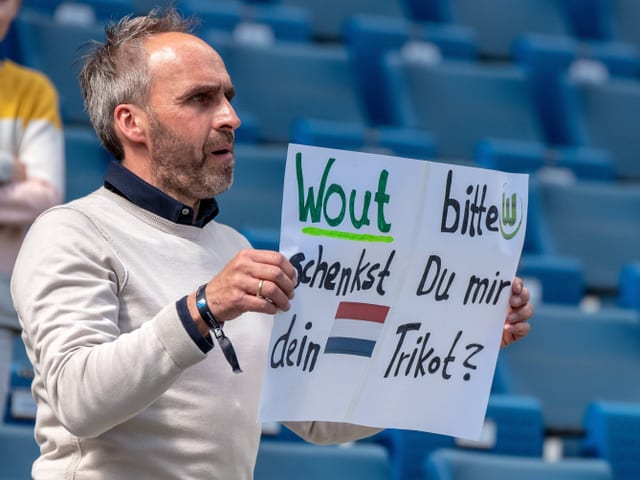 Ein Fan mit einem Plakat.