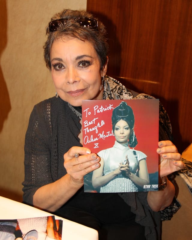 Arlene Martel streckt eine Autogramm-Karte in die Kamera Arlene Martel streckt eine Autogramm-Karte in die Kamera