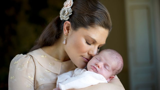Victoria hält die Nase an die Wange ihres Babys. Victoria hält die Nase an die Wange ihres Babys.