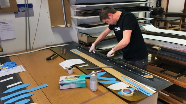 Mann arbeitet und klebt Snowboards zusammen Mann arbeitet und klebt Snowboards zusammen