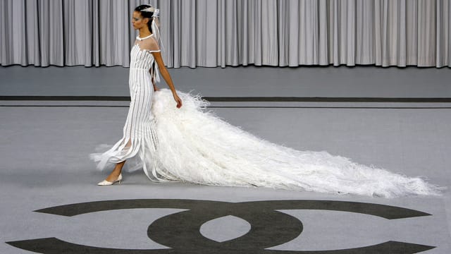 Ein Model auf dem Laufsteg. Am Boden ist das Chanel-Logo. Ein Model auf dem Laufsteg. Am Boden ist das Chanel-Logo.