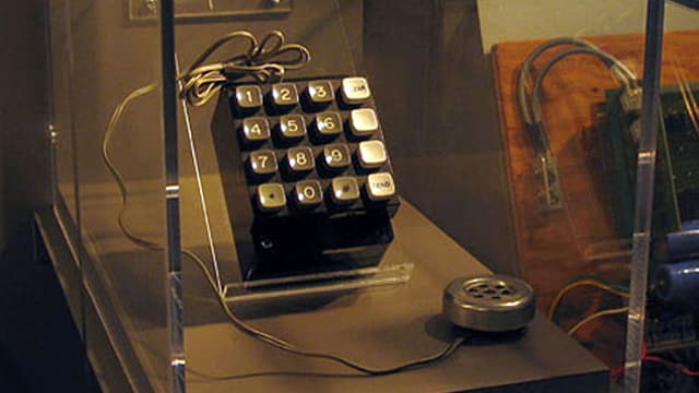 Blick auf einen Schaukasten, in dem eine verkabelte Telefontastatur zu sehen ist. Blick auf einen Schaukasten, in dem eine verkabelte Telefontastatur zu sehen ist.