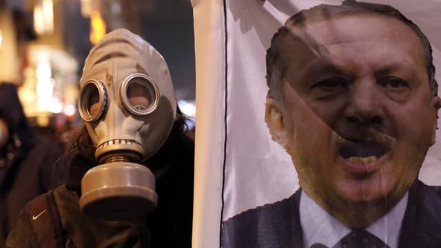 Demonstrant mit Gasmaske hält ein Plakat mit dem Konterfei Erdogans hoch. Demonstrant mit Gasmaske hält ein Plakat mit dem Konterfei Erdogans hoch.