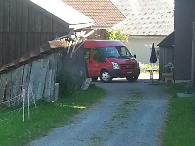 Ein roter kleiner Bus kommt zwischen den Häusern herangefahren. Ein roter kleiner Bus kommt zwischen den Häusern herangefahren.