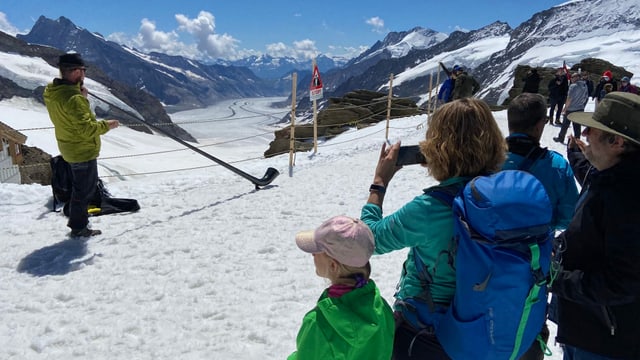 Alphornbläser vor dem Rhonegletscher, Leute hören zu und machen Fotos. Alphornbläser vor dem Rhonegletscher, Leute hören zu und machen Fotos.