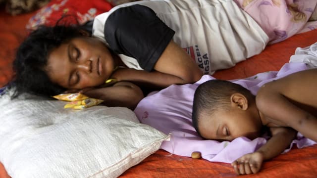 Eine Rohingya-Frau liegt schlafend neben ihrem Kind. Eine Rohingya-Frau liegt schlafend neben ihrem Kind.