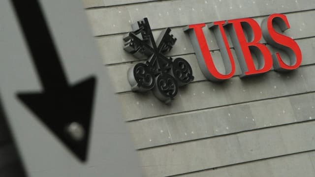 Ein Logo der UBS, daneben ein Pfeil in Abwärtsrichtung Ein Logo der UBS, daneben ein Pfeil in Abwärtsrichtung