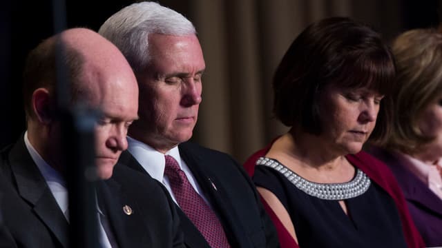 Pence und seine Frau mit geschlossenen Augen am Tisch. Pence und seine Frau mit geschlossenen Augen am Tisch.