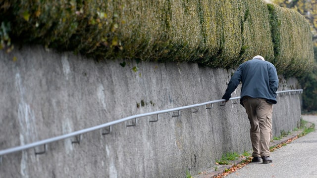 Ein älterer Herr stützt sich an einem Geländer. Ein älterer Herr stützt sich an einem Geländer.