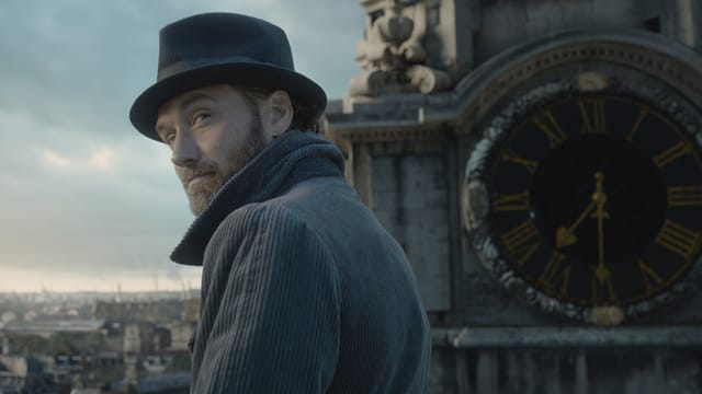 Mann mit Hut, hinten eine Kirchenuhr. Mann mit Hut, hinten eine Kirchenuhr.