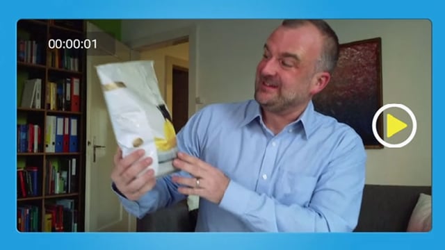 Mann betrachtet Chips-Verpackung. Mann betrachtet Chips-Verpackung.