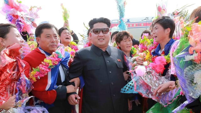 Dikator Kim Jong Un in einer jubelnden Menschenmenge. Dikator Kim Jong Un in einer jubelnden Menschenmenge.