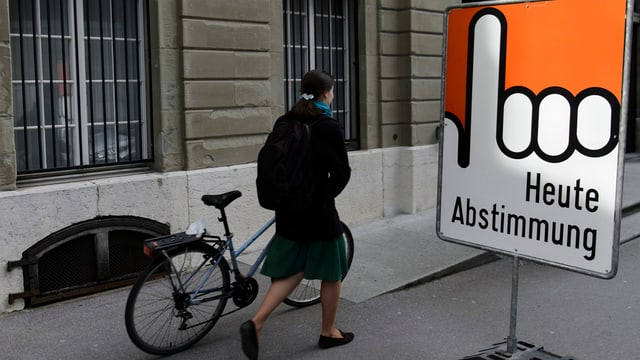 Frau läuft neben Plakat vorbei. Frau läuft neben Plakat vorbei.