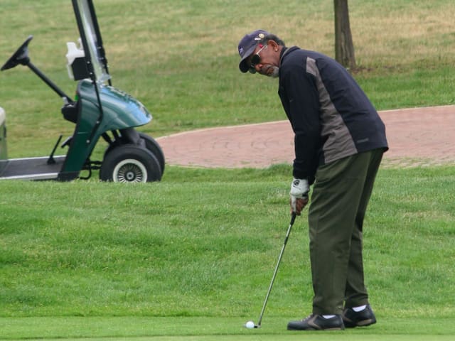 Morgan Freeman steht mit einem Goldschläger auf dem Rasen und ist kurz vor dem Abschlag. Morgan Freeman steht mit einem Goldschläger auf dem Rasen und ist kurz vor dem Abschlag.