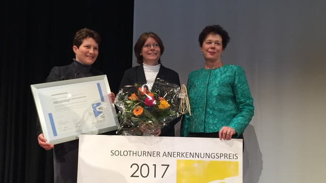 Drei Frauen mit Urkunden und Blumen. Drei Frauen mit Urkunden und Blumen.