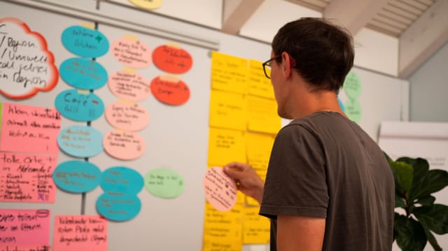 Mann vor Post-It-Zetteln Mann vor Post-It-Zetteln