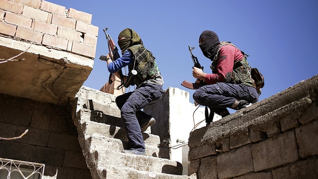 Zwei maskierte Kämpfer der verbotenen türkischen Arbeiterpartei PKK mit Gewehren auf der Terrasse eines Hauses in Nusaybin im Bezirk Diyarbakir. Zwei maskierte Kämpfer der verbotenen türkischen Arbeiterpartei PKK mit Gewehren auf der Terrasse eines Hauses in Nusaybin im Bezirk Diyarbakir.