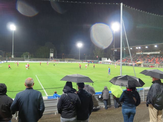 Ein paar Fans stehen im Regen. Ein paar Fans stehen im Regen.
