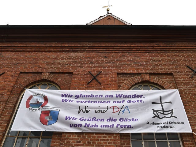 Auf einem Banner an der örtliche Kirche in Drochtersen steht: «Wir glauben an Wunder». Auf einem Banner an der örtliche Kirche in Drochtersen steht: «Wir glauben an Wunder».