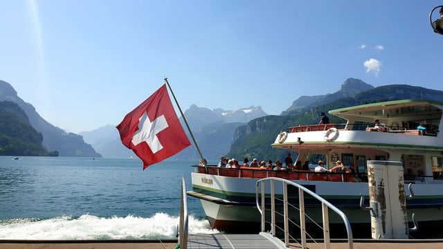 Ein Kursschiff verlässt den Steg in Brunnen, dahinter ein wolkenloser Himmel über dem Vierwaldstättersee. Ein Kursschiff verlässt den Steg in Brunnen, dahinter ein wolkenloser Himmel über dem Vierwaldstättersee.