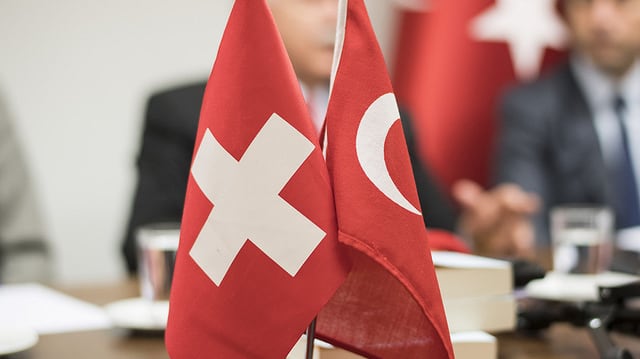 Schweizer Flagge und türkische Flagge auf Tisch Schweizer Flagge und türkische Flagge auf Tisch