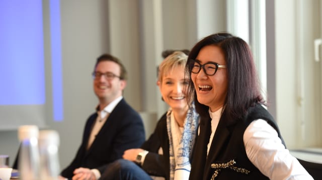 Eine chinesische Unternehmerin lacht an einer Pressekonferenz Eine chinesische Unternehmerin lacht an einer Pressekonferenz