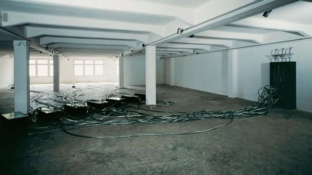 Ein raum, der aussieht wie eine Garage, es sind dunkle Kabel darin verteilt. Ein raum, der aussieht wie eine Garage, es sind dunkle Kabel darin verteilt.