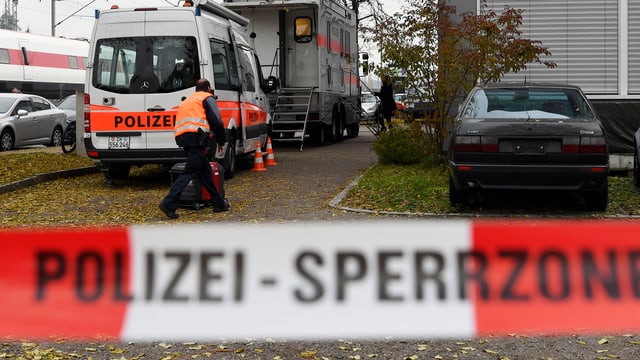 Polizeiauto und Polizisten vor Haus, vorne Absperrband Polizeiauto und Polizisten vor Haus, vorne Absperrband