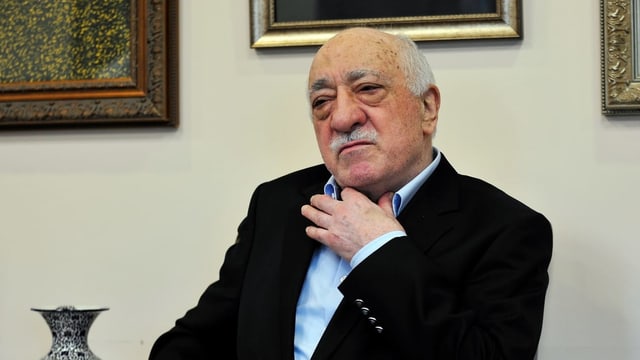 Prediger Gülen fasst sich an den Hemdskragen Prediger Gülen fasst sich an den Hemdskragen