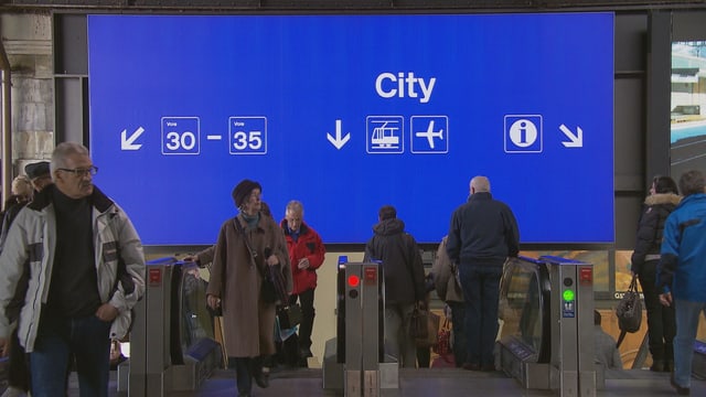 Eine grosse blaue Tafel mit verschiedenen Angaben wie City, Perronnummern und Flughafenzeichen im Basler Bahnhof. Eine grosse blaue Tafel mit verschiedenen Angaben wie City, Perronnummern und Flughafenzeichen im Basler Bahnhof.