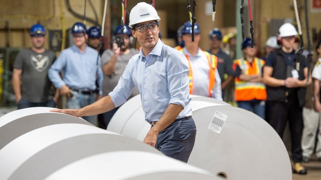 Justin Trudeau mit grossen Papierrollen. Justin Trudeau mit grossen Papierrollen.