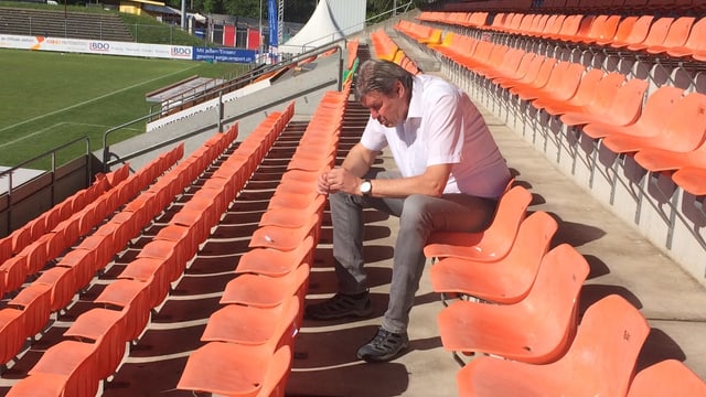 Mann auf Sitztribühne in einem Fussballstadion. Mann auf Sitztribühne in einem Fussballstadion.