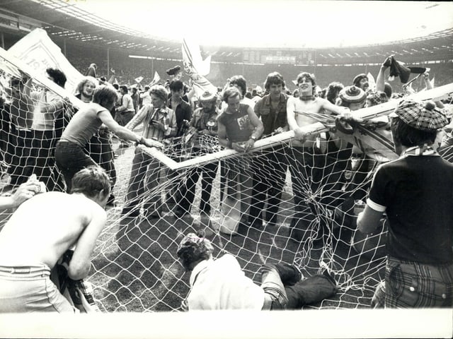 Schottische Fans nehmen ein Wembley-Tor auseinander. Schottische Fans nehmen ein Wembley-Tor auseinander.